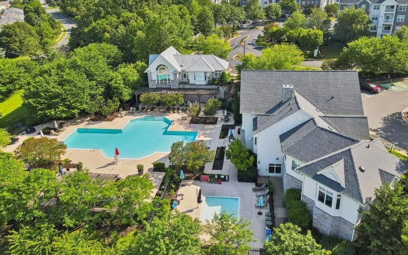 a swimming pool surrounded by trees and buildings