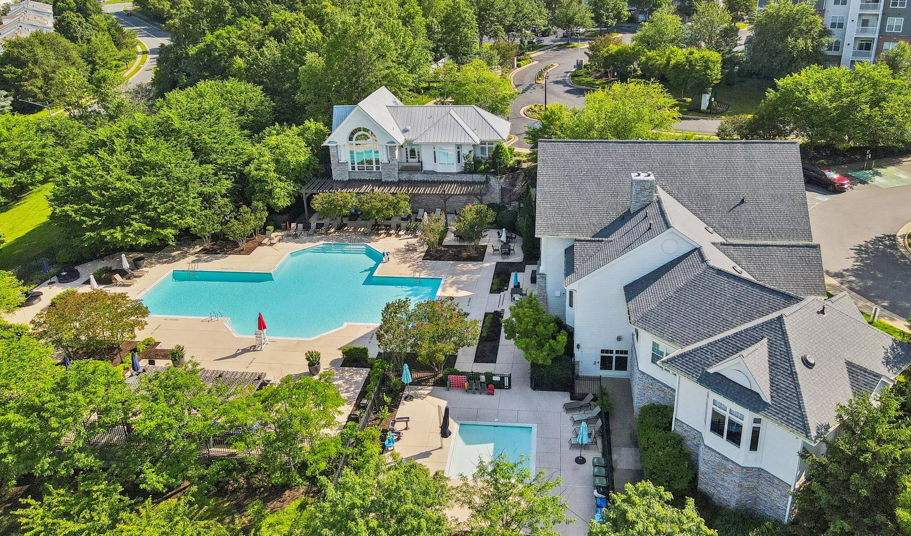 a swimming pool surrounded by trees and buildings