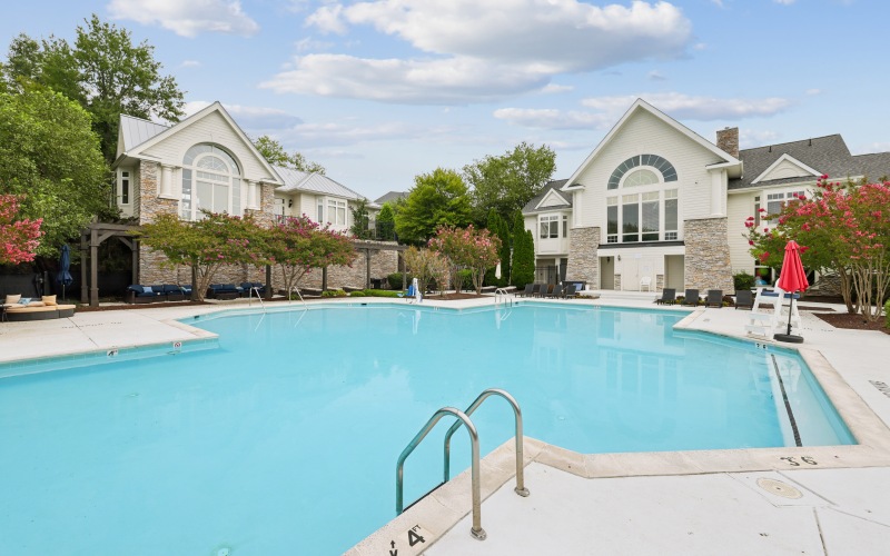 a swimming pool surrounded by trees and buildings